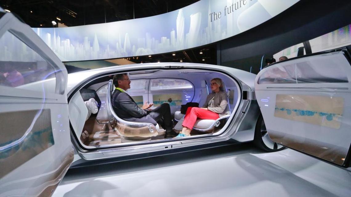 Asistentes a la Feria de tecnología prueban un modelo de Mercedes-Benz F 015 en el kiosco de la firma alemana Mercedes-Benz, el año pasado. Los vehículos autónomos y los sistemas de navegación que se muestran en el parabrisas son unos de los atractivos del evento.