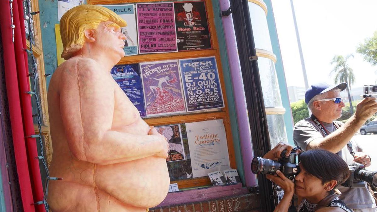 Una estatua desnuda del candidato republicano Donald Trump llama la atención de varios transeúnte el jueves 18 de agosto de 2016, quienes se fotografían con ella en Los Ángeles (EEUU). La instalación de la obra artística no fue autorizada por ninguna autoridad local y fue creada por el grupo de artistas Indecline, quienes se auto describieron como uno grupo de artistas anarquistas. Otras ciudades donde la estatua hizo su aparición fueron San Francisco, Seattle, Cleveland y Nueva York.