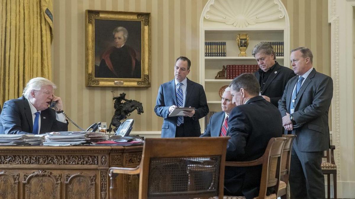 Foto del 28 de enero de 2017, el presidente Donald Trump, acompañado por el el vicepresidente Mike Pence, y los entonces Jefe de Gabinete Reince Priebus, asesor de seguridad nacional Michael Flynn, asesor principal Steve Bannon y secretario de prensa de la Casa Blanca Sean Spicer, mientras habla por teléfono con el presidente ruso, Vladimir Putin, en la Oficina Oval de la Casa Blanca en Washington.