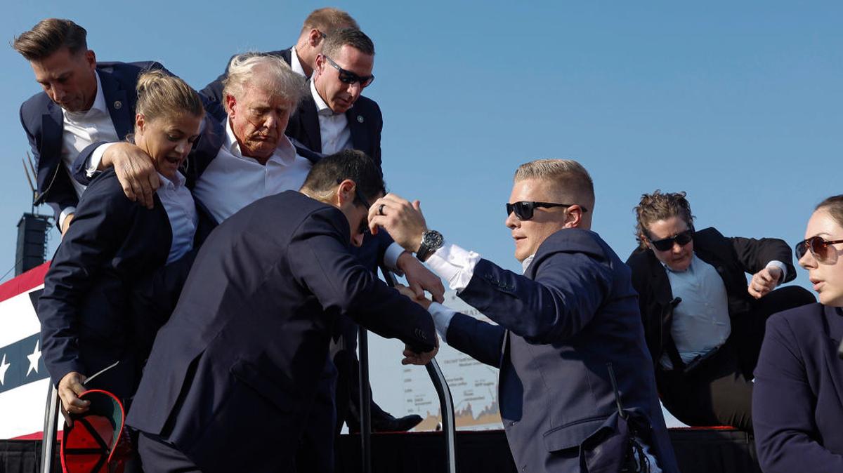 El candidato presidencial republicano y ex presidente Donald Trump es sacado del escenario por agentes del Servicio Secreto de Estados Unidos después de ser rozado por una bala durante un mitin, el 13 de julio de 2024 en Butler, Pensilvania.