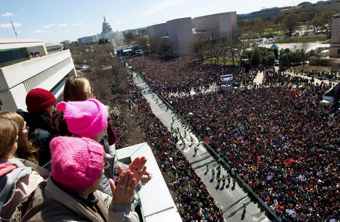 Espectadores desde el balcón del Newseum, en Washington, observan a los manifestantes el 24 de marzo en Pennsylvania Avenue durante la protesta para pedir mayor control de las armas en EEUU.