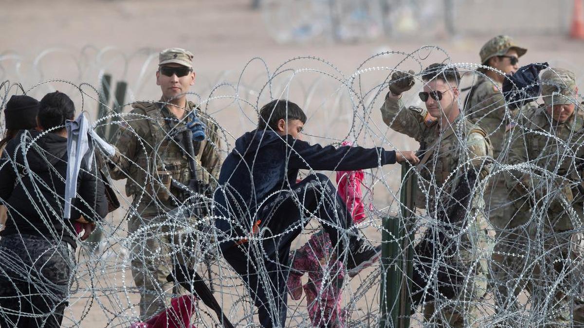 Soldados de la Guardia Nacional de Texas impiden que un solicitante de asilo ingrese a los EEUU por el Río Grande en El Paso, Texas, el 6 de marzo de 2024.