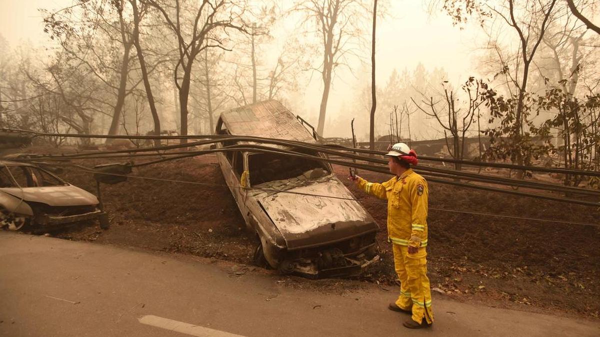 Un bombero inspecciona vehículos incendiados al costado de la carretera después de que el incendio del Campamento atravesó el área en Paradise, California el 10 de noviembre de 2018.