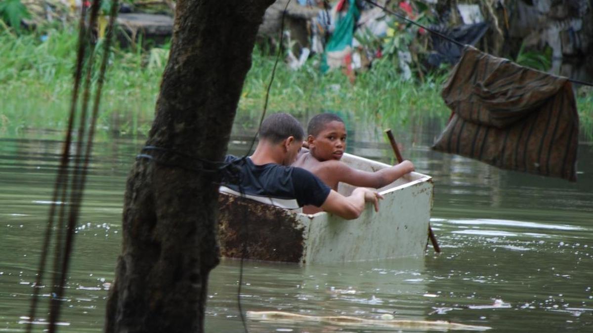 Dos niños navegan en una rústica canoa tras el avance del huracán Matthew en República Dominicana. El ojo del huracán tocó tierra el martes en el oeste de Haití y el extremo oriental de Cuba, indicó el Centro Nacional de Huracanes (NHC) de EEUU.