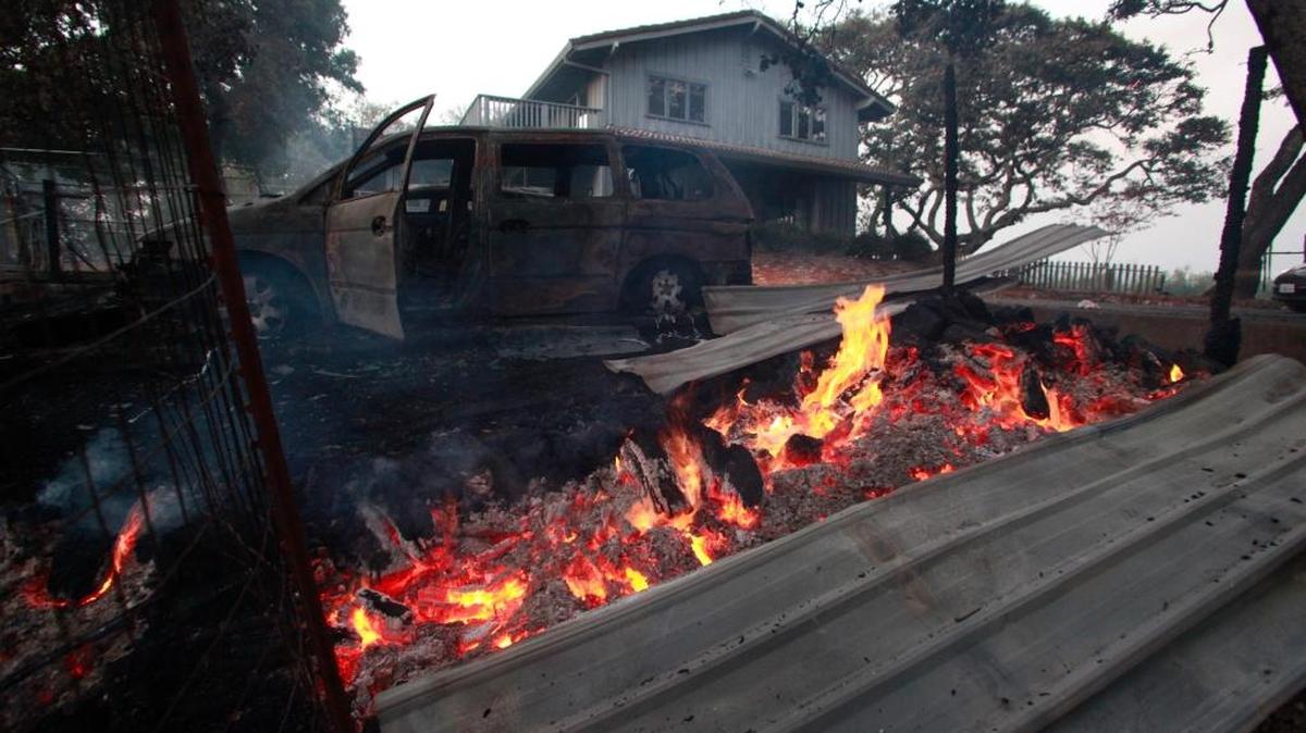 El fuego consume dos autos en una casa ya destruida en los incendios en Kenwood, California, el 10 de octubre.