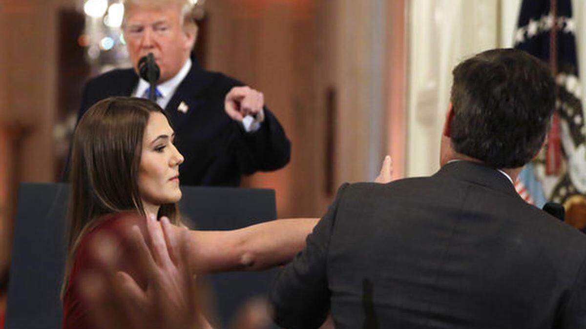 Mientras el presidente Donald Trump apunta su dedo hacia el reportero de CNN Jim Acosta (a la derecha), una asistente de la Casa Blanca toma el micrófono que él tiene en su mano todavía durante una conferencia de prensa en la Casa Blanca, el miércoles 7 de noviembre de 2018, en Washington.