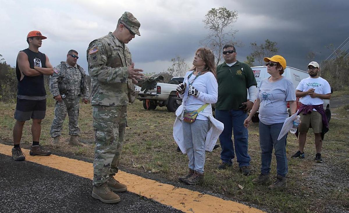 Ricardo Garraton, coronel del Ejército, habla con la activista comunitaria Mimi Ortiz, tras aterrizar junto al Observatorio de Arecino en un helicóptero con un grupo de la Fuerza Aérea para entregar suministros en la aislada localidad de Carso, tras el paso de María.