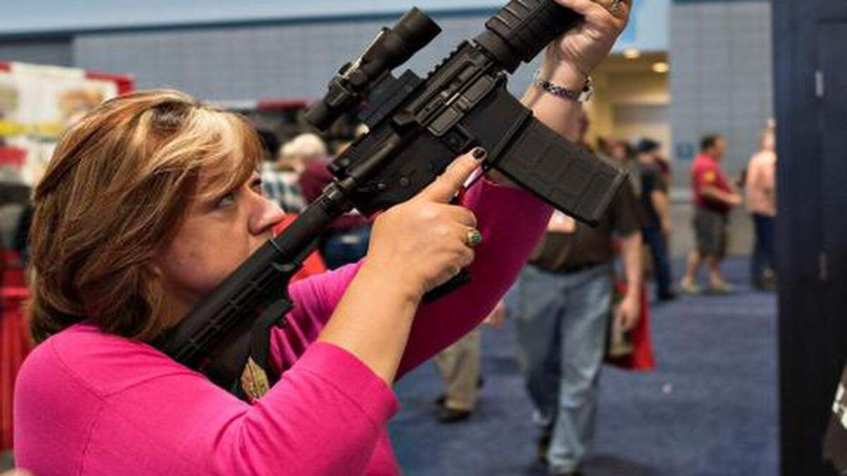 
Una mujer examina un rifle durante la convención de la NRA. Imagen de archivo.
