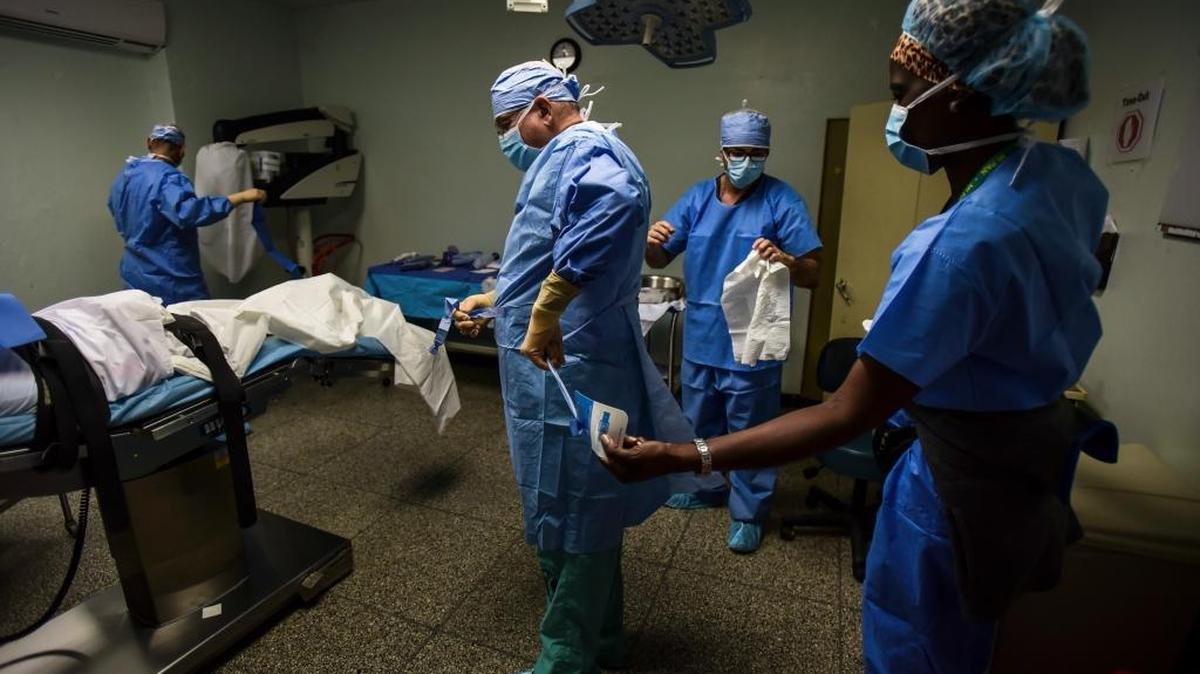 El doctor Reynold López (centro), uno de los pocos cirujanos oncólogos de la isla y profesor de la escuela de medicina de la Universidad de Puerto Rico se prepara para una cirugía de tiroides junto al doctor Isaac Gonzalez Martinez en el Hospital Oncológica de San Juan, Puerto Rico.