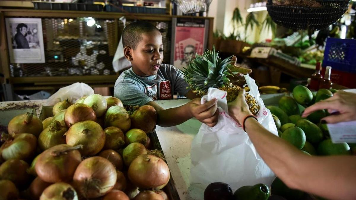 Yoniel Santana trabaja en el puesto de productos agrícolas de su mamá en La Placita de Santurce.