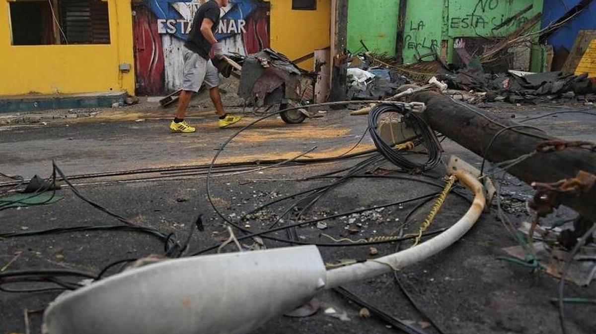 Un residente de La Perla, en San Juan, limpia los escombros que dejó el huracán María.