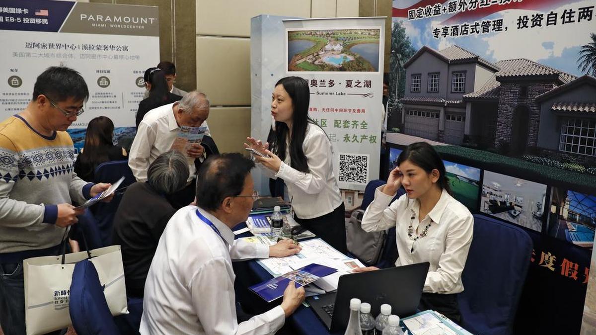 Los visitantes chinos buscan información del programa de visas EB-5 del gobierno estadounidense en las cabinas de los expositores en una cumbre Invest in America Summit, en Beijing el domingo 7 de mayo de 2017.