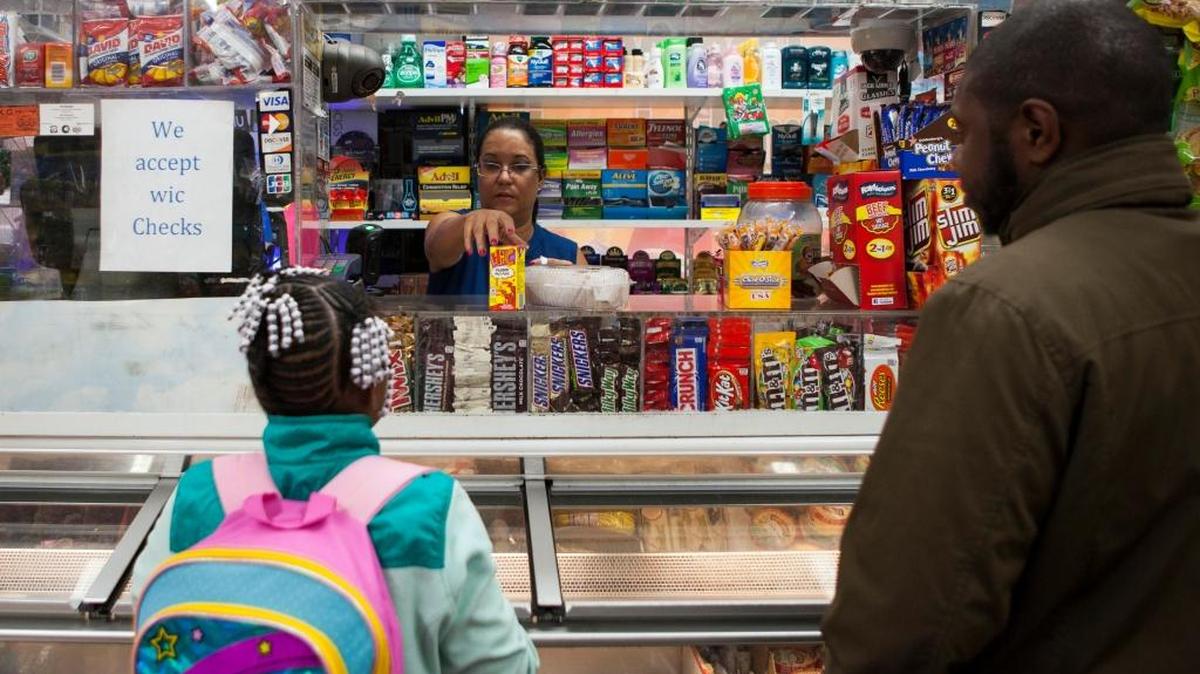 Rosaria Díaz (centro) despacha una bebida Hi-C a base de frutas a Zakiyaa Sillman, en Corner Food Market, en el Norte de Filadelfia, el 22 de septiembre. Los norteamericanos sustituyen las sodas por opciones más saludables.