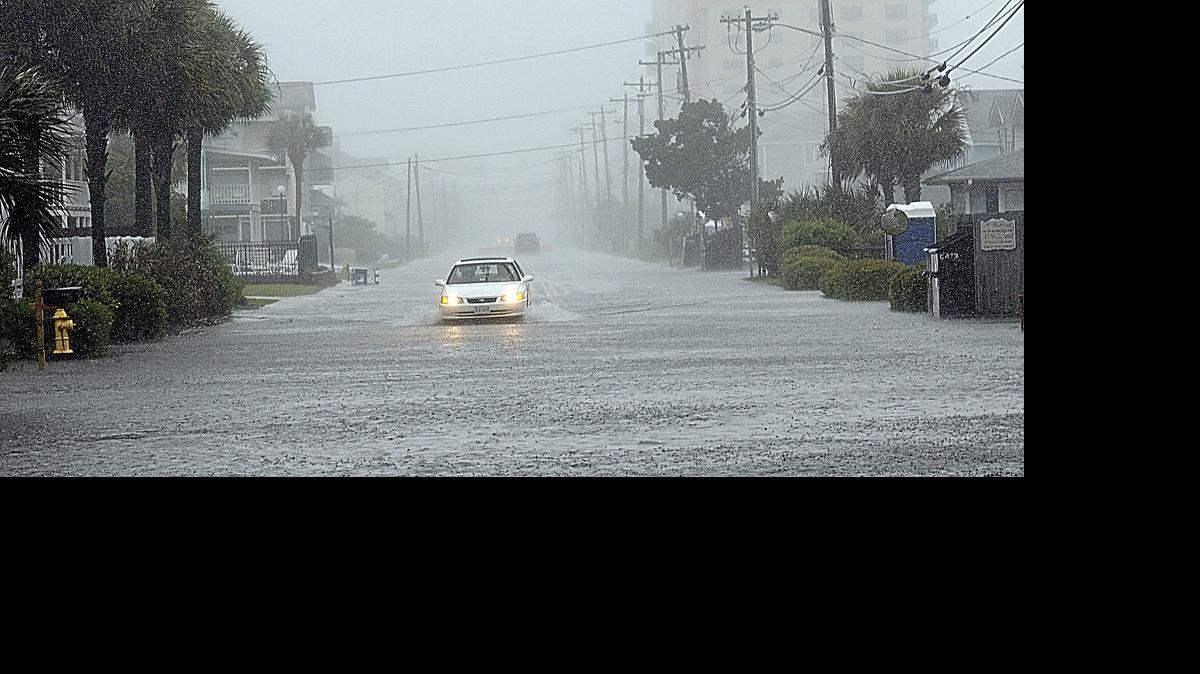 
Un auto transita el domingo por una calle anegada en North Myrtle Beach, Caronila del Sur, tras el paso de la tormenta Ana.
