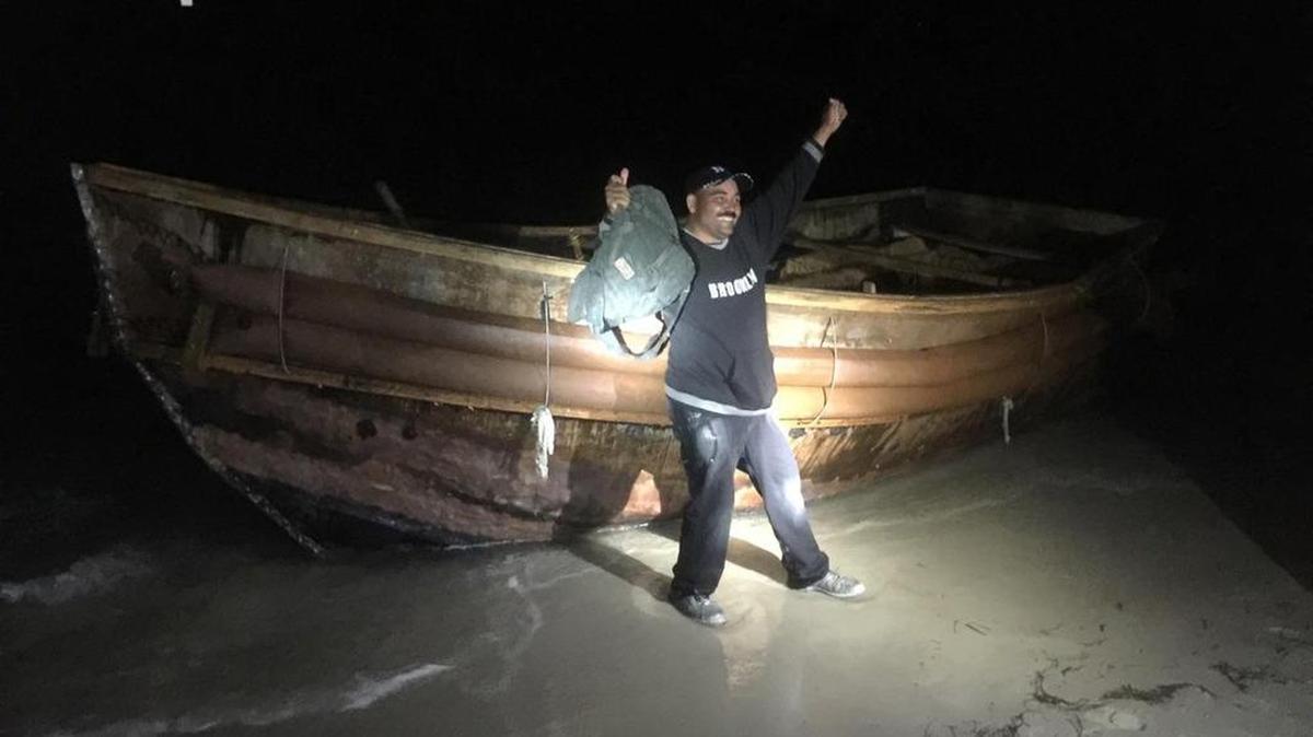 Fotografía del miércoles 27 de abril de 2016, divulgada por la policía de Cayo Hueso (Florida), el punto más meridional de EEUU., que muestra a uno de los veintitrés balseros cubanos, llegando anoche a una playa de esa ciudad.