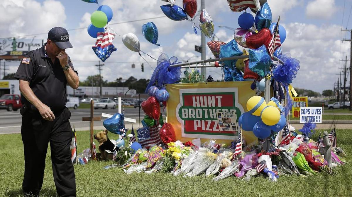 El policía de New Jersey, Bob Ossler, visita un monumento improvisado para tres agentes de policía el 19 de julio de 2016 Baton Rouge, Louisiana.