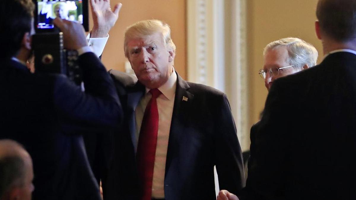 El presidente Donald Trump, seguido por el líder de la mayoría en el Senado, Mitch McConnell, saluda al llegar a almorzar con los senadores republicanos en el Capitolio de los EEUU en Washington, el martes 24 de octubre de 2017.