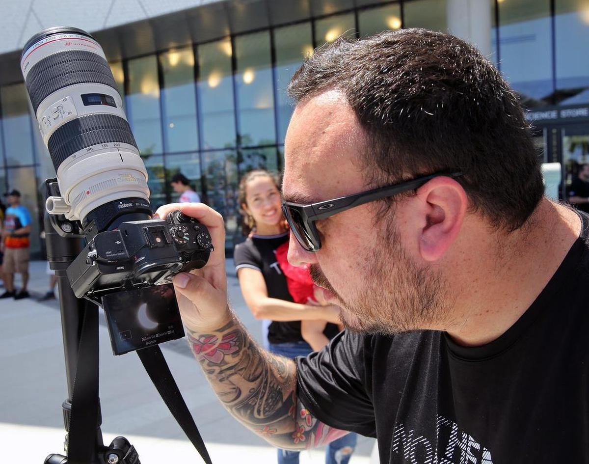 José Botero toma fotos del eclipse parcial de sol en el Museo Frost en el centro de Miami el lunes 20 de agosto de 2017.