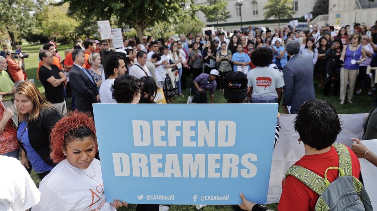 Una pancarta que dice “Defiende a los soñadores” es sostenida por dos de los cientos de activistas que protestaron a favor de un proyecto de ley de reforma migratoria, el martes frente al Congreso en Washington D.C.