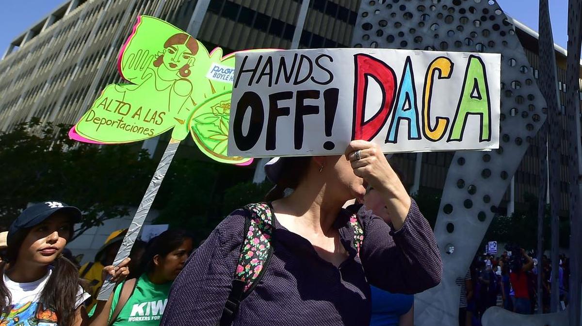 Jóvenes inmigrantes y simpatizantes caminan sosteniendo carteles durante un mitin en apoyo a DACA en Los Ángeles, California el 1 de septiembre de 2017.