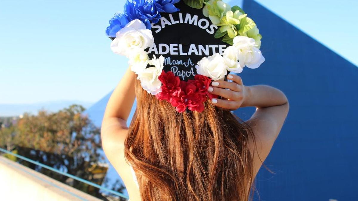 Fotografía del 20 de mayo de 2017 cedida por Jazmín Jiménez donde ella posa con su propio birrete con el que se graduó en la Universidad en California, con el que quiso celebrar a sus padres y fusionar las banderas de México y Estados Unidos con los colores de las flores, en California State University Long Island.