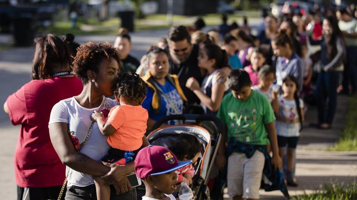 Familias esperan para recibir uniformes y ayuda en centro de asistencia el viernes 8 de agosto de 2017, en Houston, Texas.