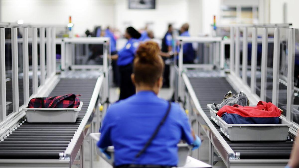 ARCHIVO - En imagen de archivo del 25 de mayo de 2016, bandejas con pertenencias de pasajeros pasan por la zona de rayos X en el Área renovada de inspección de equipaje de mano en el Aeropuerto Internacional Hartsfield-Jackson de Atlanta. (AP Foto/David Goldman, archivo)