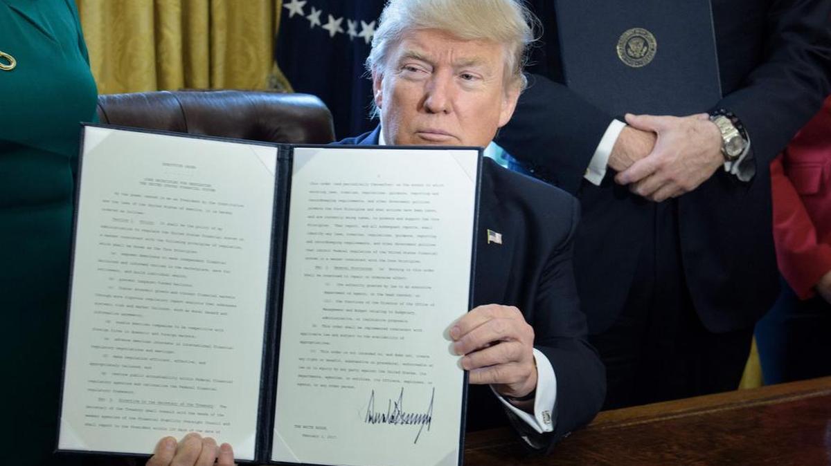El presidente de los Estados Unidos, Donald Trump, muestra una orden ejecutiva que ordena al Secretario del Tesoro revisar la ley de supervisión financiera Dodd-Frank en la Oficina Oval de la Casa Blanca el 3 de febrero de 2017 en Washington, DC.