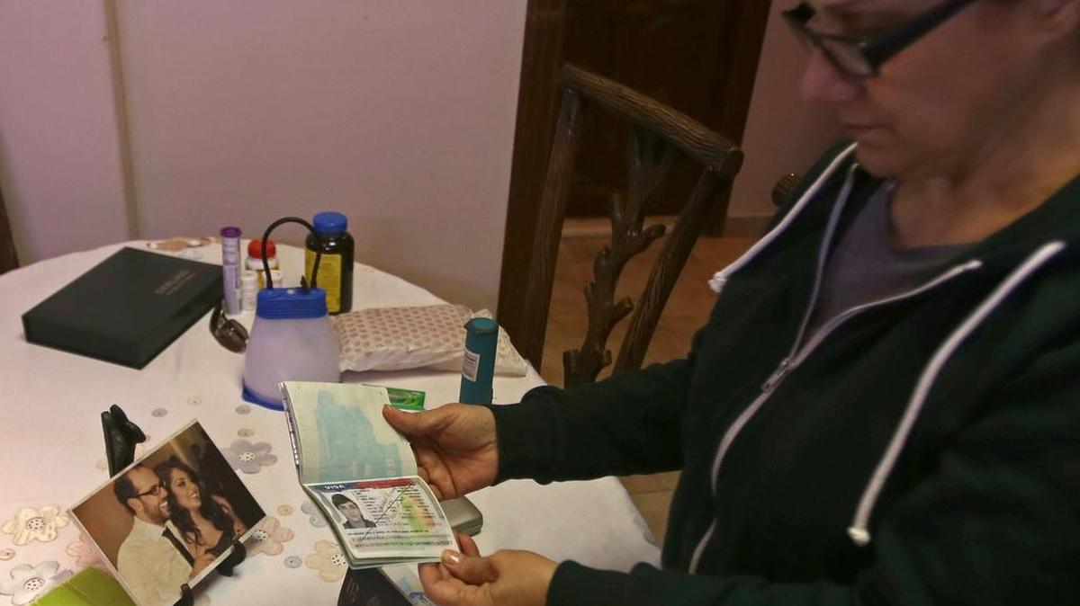 Josephine Abu Assaleh se encuentra en su casa en Damasco el 30 de enero de 2017 mirando el visado americano en su pasaporte que fue cancelado tras las nuevas restricciones de inmigración del presidente de Estados Unidos, Donald Trump.