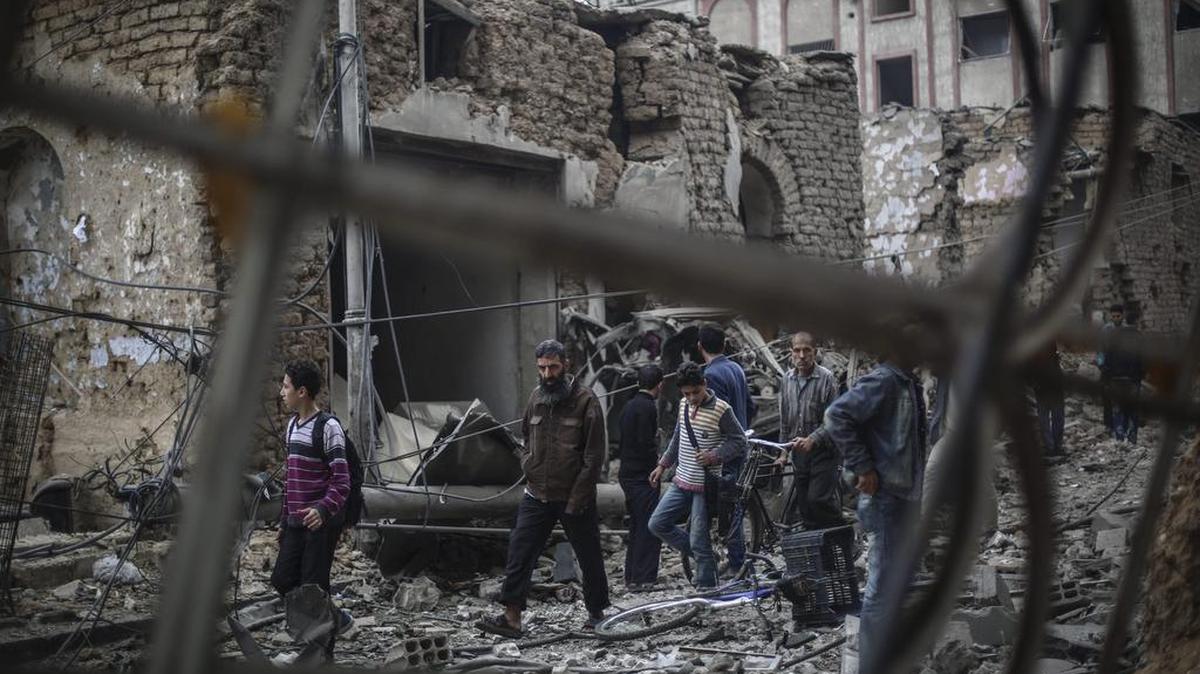 Ciudadanos sirios observan los daños ocasionados tras un bombardeo contra un hospital de campaña en Douma, a las afueras de Damasco, Siria, el 29 de octubre de 2015.