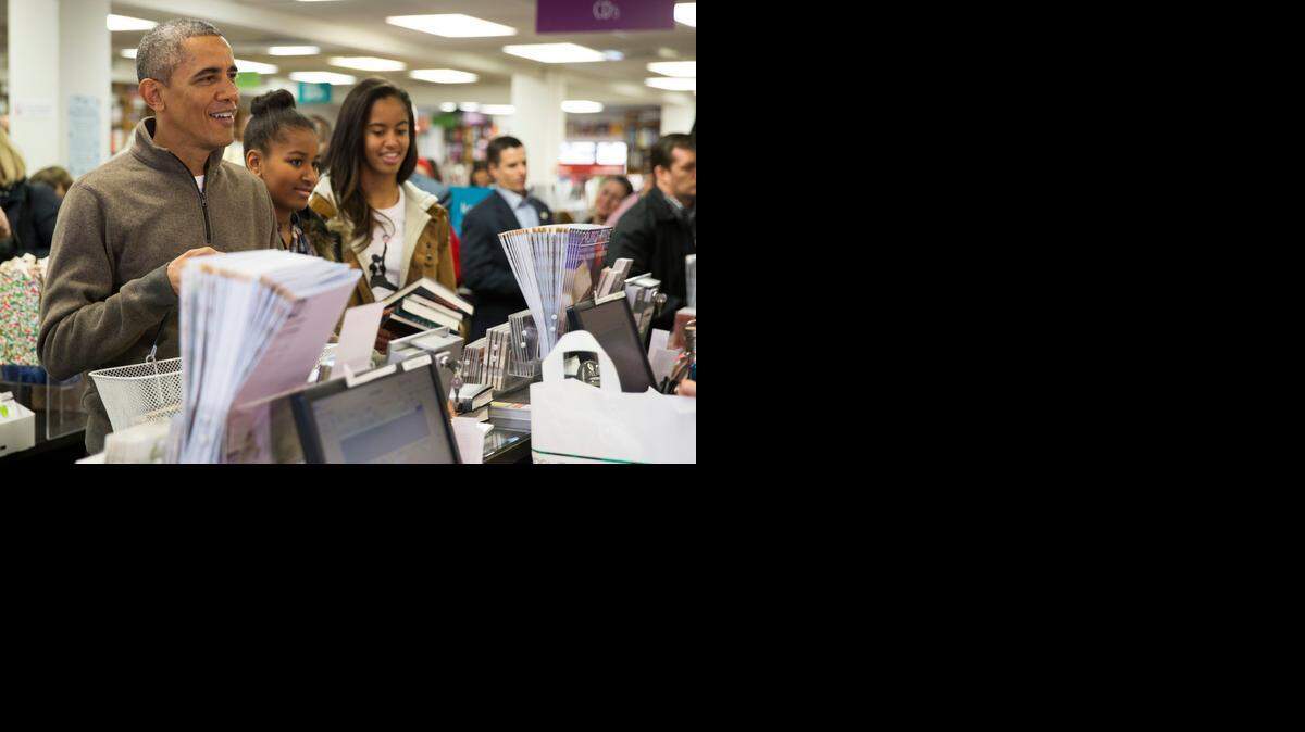 
El presidente Barack Obama compra libros el sábado con sus hijas en una tienda en Washington.


