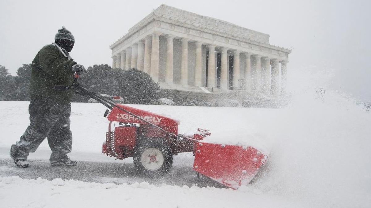 Un trabajador limpia, frente al Monumento a Lincoln en Washington DC, la nieve caída durante el paso de la tormenta Jonas que se espera deje entre 12 y 30 pulgadas de nieve.