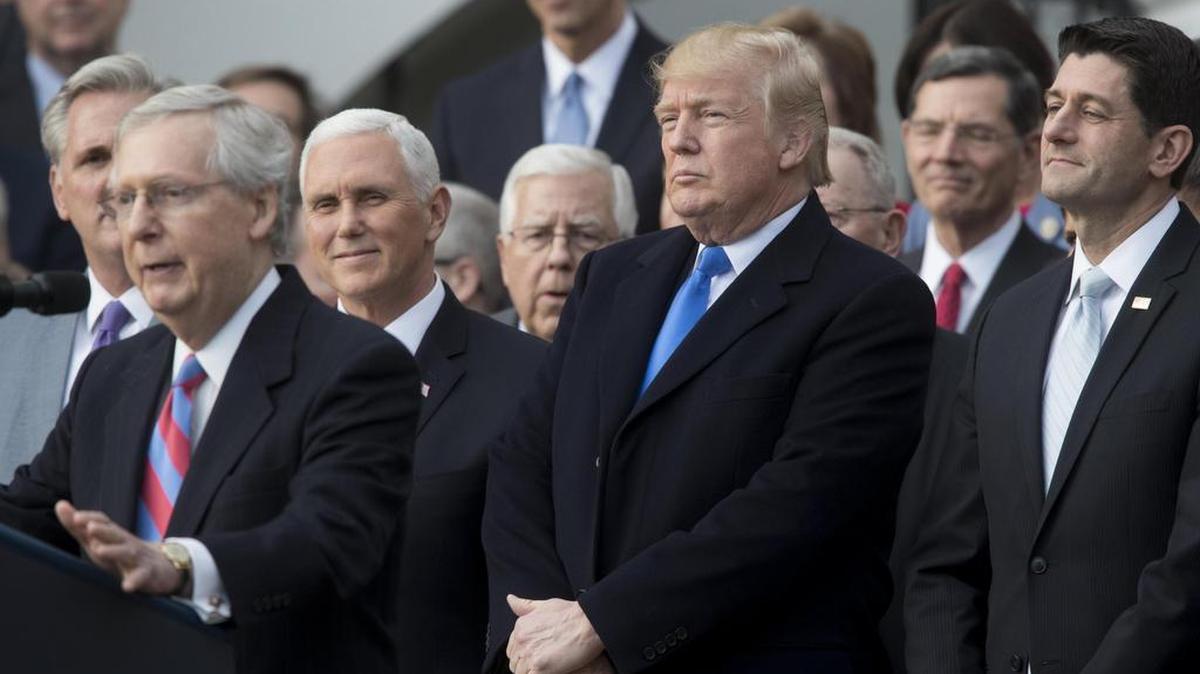 El presidente de los Estados Unidos, Donald Trump (2-d), el portavoz de la Cámara, Paul Ryan (d), y el vicepresidente Mike Pence (2-i), escuchan el discurso del senador republicano Mitch McConnell (i), durante una ceremonia con motivo de la aprobación de la reforma fiscal el miércoles 20 de diciembre de 2017, en Washington.