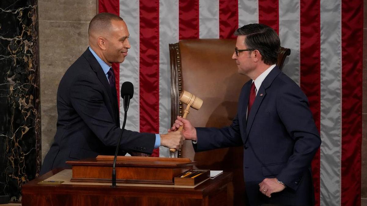 El líder de la minoría de la Cámara de Representantes, Hakeem Jeffries, demócrata de Nueva York, le entrega el mazo al presidente de la Cámara de Representantes, Mike Johnson, durante la primera sesión del 119.º Congreso en el Capitolio de los Estados Unidos en Washington, DC, el 3 de enero de 2025.