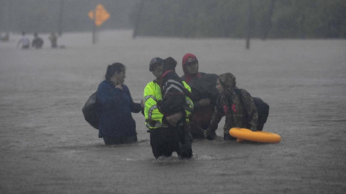 Una familia camina por calles inundadas después del paso del huracán Harvey en Houston, Texas, el 28 de agosto.