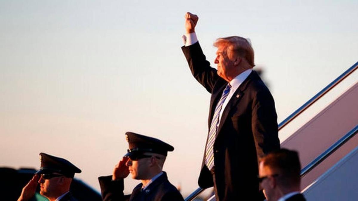 El presidente Trump saluda a su llegada el viernes al aeropuerto internacional de Palm Beach.