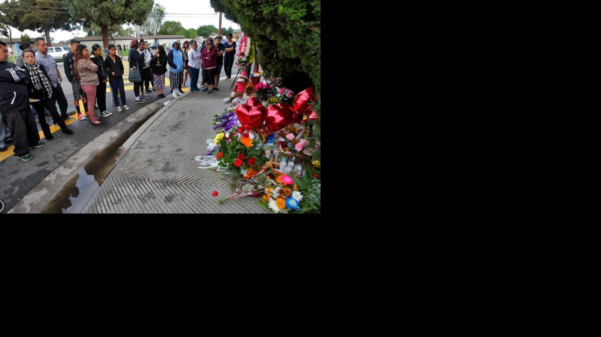 
Amigos y vecinos se reúnen el sábado en Santa Ana, California, frente al lugar donde tres niñas de 13 años murieron tras ser atropelladas en Halloween.
