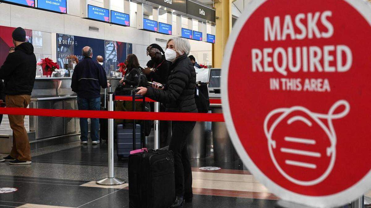 Los pasajeros esperan para registrarse para su vuelo en el Aeropuerto Internacional Ronald Reagan en Washington, DC el 27 de diciembre de 2020. - El caos de viajes global que convulsionó el fin de semana de Navidad se extendió hasta el lunes con importantes cancelaciones de vuelos que afectaron a millones que regresan de las vacaciones, como Covid-19 los casos aumentan a niveles récord en Europa y varios estados de EE. UU. Foto de ROBERTO SCHMIDT / AFP via Getty Images.