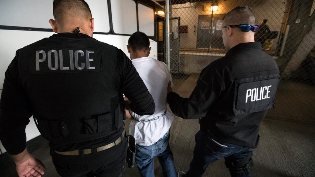 Juan Vega (centro) es escoltado por agentes del ICE a una instalación de esa agencia en Los Angeles en abril del 2017.