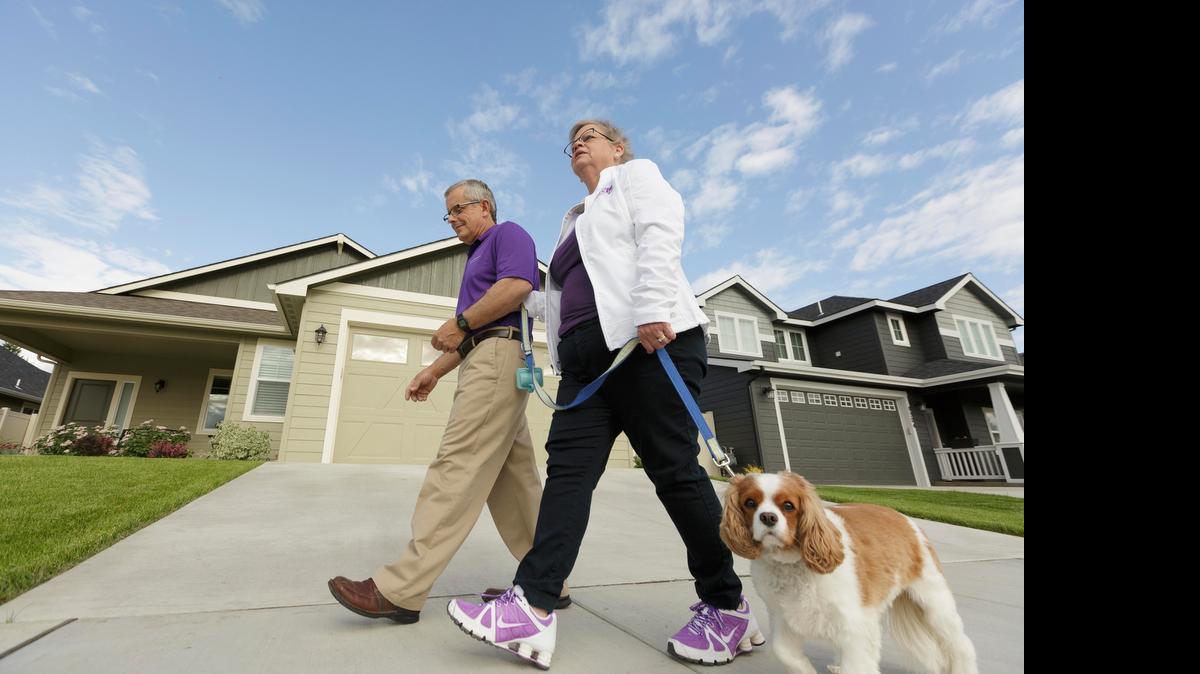 
Amy Shives y esposo George pasean a su perro en junio en Spokane, Washington. Shives fue diagnosticada con la enfermedad de Alzheimer en el 2011. 
