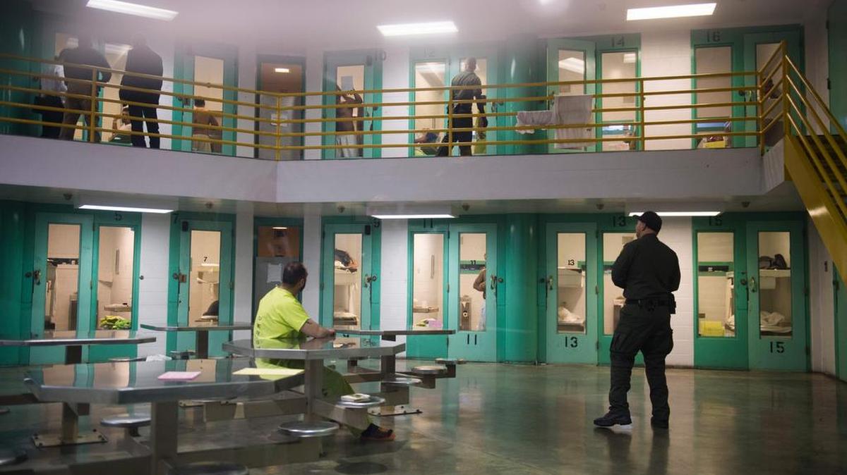 Un asistente del alguacil habla con un detenido de inmigración en una unidad de vivienda de alta seguridad en Theo Lacy Facility, una cárcel del condado que también alberga detenidos de inmigrantes detenidos por el Servicio de Inmigración y Control de Aduanas (ICE, por sus siglas en inglés).