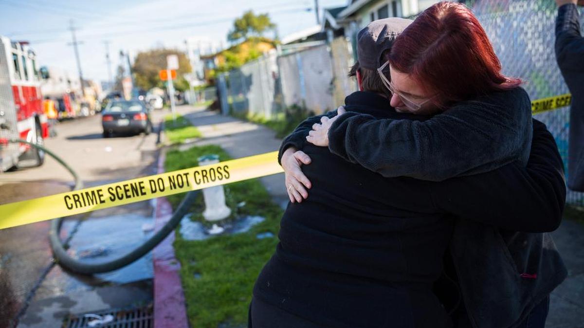 Personas se reúnen cerca de un almacén después de que fue destruido por un incendio en el que han muerto más de tres decenas de personas en Oakland, California.