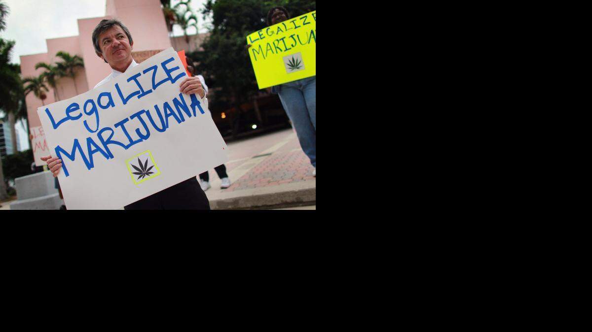 
El candidato a la Fiscalía General de Florida, Jim Lewis, sostiene un cartel a favor de legalizar la marihuana, durante una manifestación el lunes en Fort Lauderdale.
