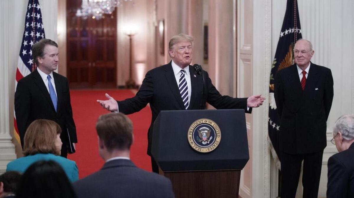 El presidente de Estados Unidos, Donald Trump (c), habla junto al juez asociado de la Corte Suprema, Brett Kavanaugh (i), y el juez asociado Anthony Kennedy (d), el lunes 8 de octubre de 2018, en la Sala Este de la Casa Blanca en Washington, DC.