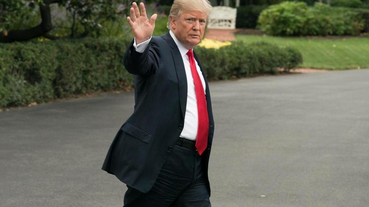 El presidente estadounidense Donald Trump saluda mientras camina por el jardín sur de la Casa Blanca en Washington para subir al Marine One el 11 de octubre de 2017, para viajar a Harrisburg, Pensilvania.