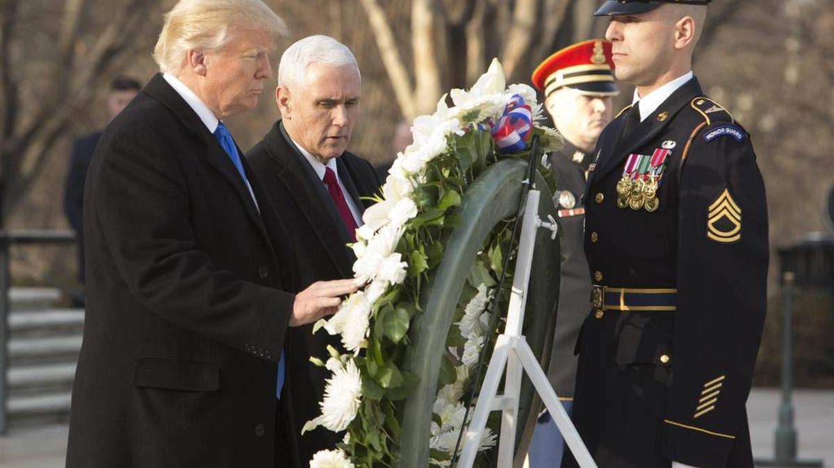 El presidente electo de Estados Unidos, Donald Trump (i), acompañado de su vicepresidente, Mike Pence (c), inicia el 19 de enero de 2017, la agenda de actos oficiales de su investidura con una ofrenda floral en la tumba del soldado desconocido en el cementerio militar de Arlington (Virginia).