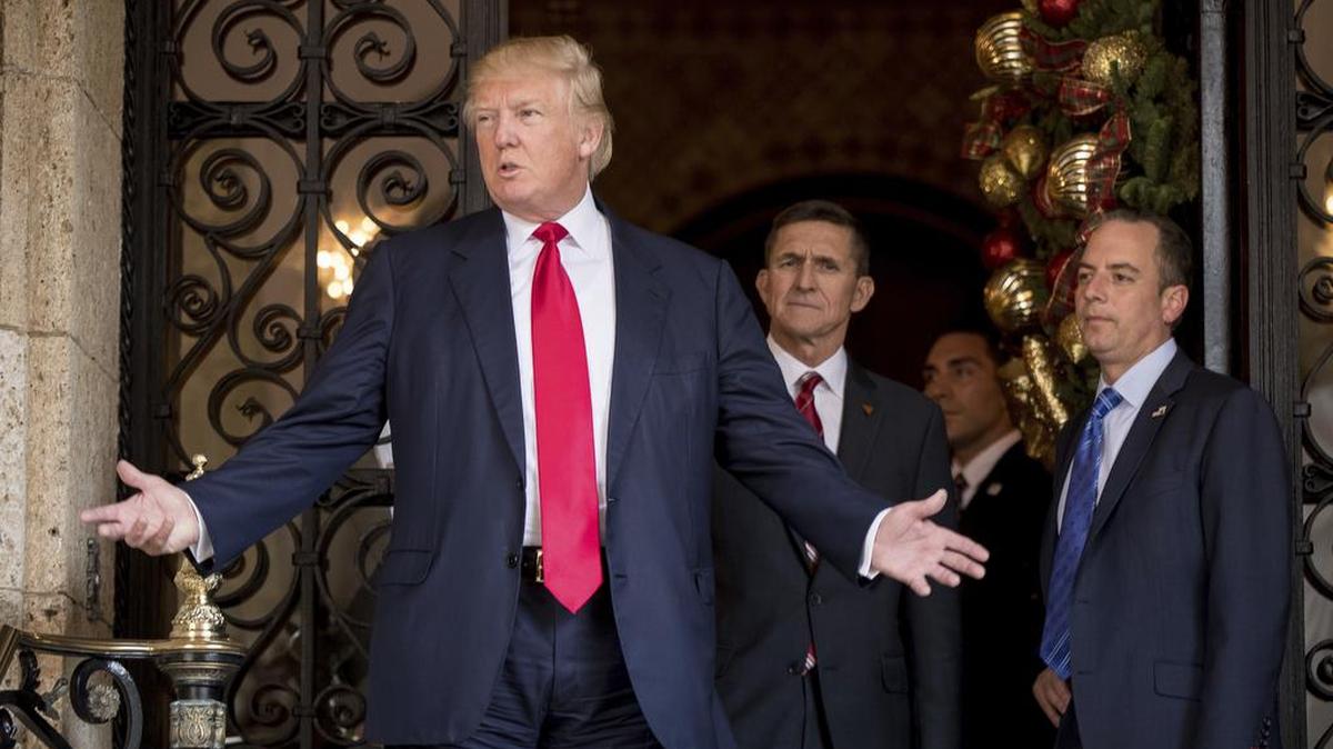 El entonces presidente electo Donald Trump frente a su asesor Michael Flynn (izq.) en Mar-a-Lago, Palm Beach, el 21 de diciembre de 2016.