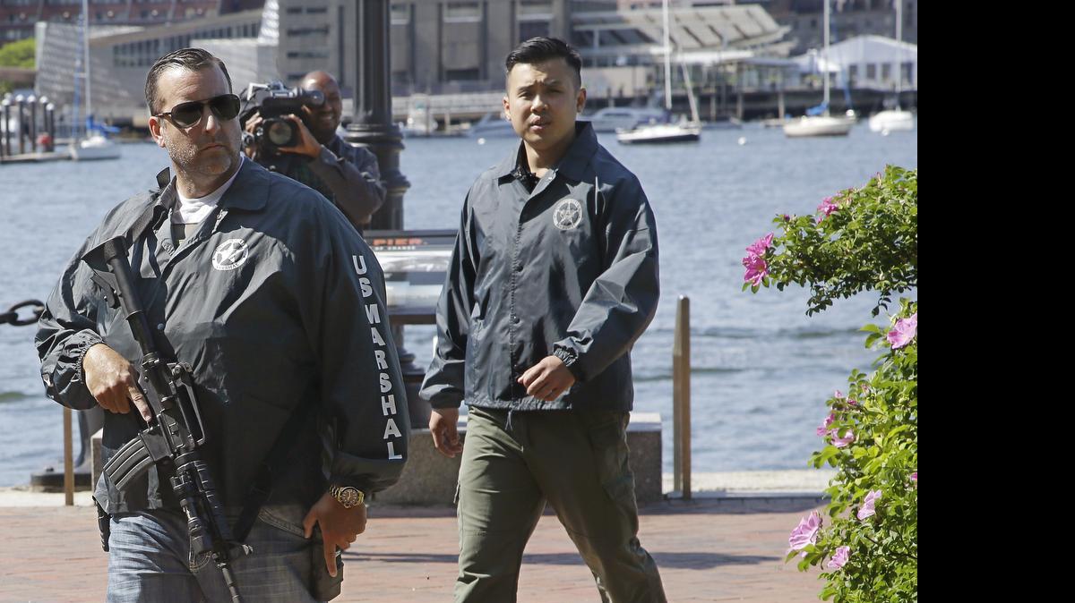 
Agentes federales custodian un área cercana a la corte donde se presentó el miércoles el sospechoso David Wright. Debajo, el acusado en un dibujo en el tribunal de Boston.
