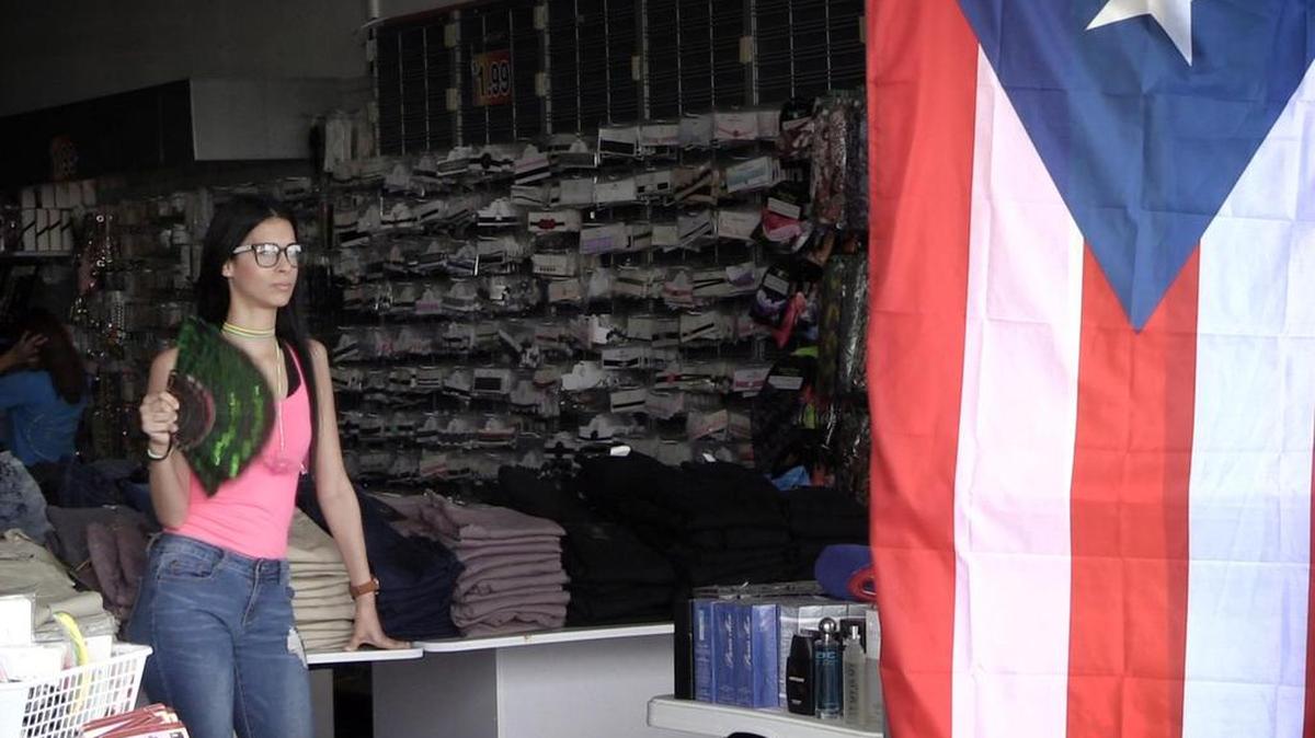 Xaira García trata de refrescarse con un abanico en su trabajo en una tienda en Carolina, Puerto Rico, el 4 de octubre del 2017.