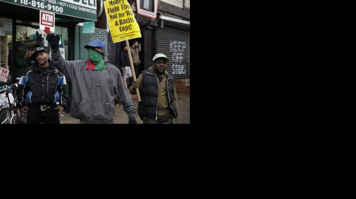 <cutline_leadin>manifestantes</cutline_leadin> <cutline_leadin>protestan</cutline_leadin> cerca del sitio donde Eric Garner murió el pasado 17 de julio por asfixia después que un policía colocara su brazo alrededor de su cuello y ejecutara una llave de estrangulamiento prohibida en el estado de Nueva York.